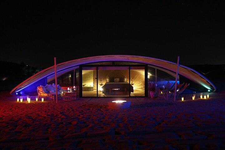 Experience the magic of desert nights as you unwind in luxury tents savor gourmet cuisine and enjoy starlit gatherings amidst the tranquil beauty of Dubai’s dunes.